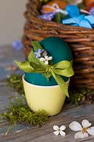 Oeufs de Pâques teints décorés avec ruban et fleurs délicates