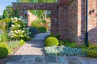Un jardin dans un jardin de campagne moderne du Cheshire, conçu par Louise Harrison-Holland. La plantation comprend des balles et des haies taillées, des Hydrangea paniculata, des Stachys et des Veronicastrums