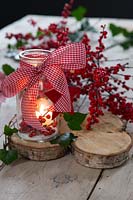 Lanterne festive décorée avec des baies et un ruban