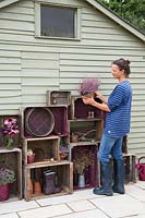 Femme rempoter des plantes pour ajouter sur le stockage de caisse en bois vintage
