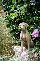 Petit jardin avec statue de chien en gravier avec des herbes. Hackney, Londres