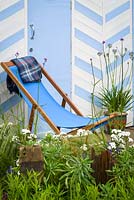 Chaise de terrasse en bois bleu avec Achillea ptarmica 'The Pearl' et Verbena bonariensis. By The Sea - RHS Hampton Court Palace Flower Show 2017 - Conception: James Callicott - Parrain: Southend Borough Council.