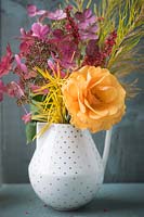 Bouquet de fleurs d'automne dont la rose parfumée à l'orange, Persicaria amplexicaulis - bistort rouge, Hydrangea paniculata, Amsonia hubrichtii et des fleurs séchées de Stipa gigantea dans un vase sur fond de bois sombre.
