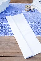 Faire un pompon en papier à partir de serviettes. Retournez et faites un autre pli de la pile de serviettes et appuyez fermement sur le pli. Continuez jusqu'à ce que vous ne puissiez plus faire de plis et que vous ayez une longue bande.