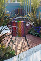 Chaises de jardin colorées avec plantation de bambou, de phormium et de Pericallis x hybrida 'Senetti Deep Blue' - Ocean Garden, RHS Malvern Spring Festival 2017