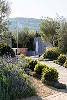 Patio avec cuisine extérieure, piscine chauffée et coin salon entouré d'oliviers dans une grande jardinière en terre cuite - The Retreat, RHS Malvern Spring Festival 2017
