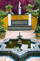 Fontaine et piscine de style mauresque avec dallage et décoration murale en mosaïque. Casa de Pilatos, Séville, Espagne.