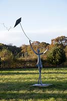 Fille volant une sculpture de cerf-volant par Christopher Linsey