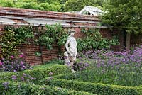 Une statue classique surplombe un parterre formel planté de Verbena bonariensis.