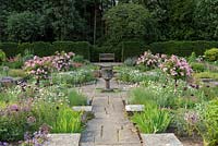 Jardin de Sylvia à Newby Hall, une disposition formelle et submergée de parterres de fleurs avec un broyeur de maïs en pierre byzantine.
