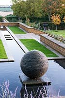 Long ruisseau de terrasse se terminant en piscine avec une pièce d'eau en sphère d'ardoise créée par le sculpteur James Parker.