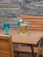 Cruche et verres sur table en bois dans le jardin urbain
