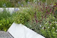 Un jardin moderne planté de Lysimachia atropurpurea 'Beaujolais', Deschampsia cespitosa, Amsonia, Iris. RHS Chelsea Flower Show