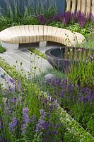 Jardin urbain contemporain avec siège en bois de forme organique et bassin à eau. Designer Rae Wilkinson