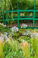 Un petit jardin dans le style du jardin de Monet à Giverny avec étang, pont et Agapanthe. Exposition florale de RHS Hampton Court.