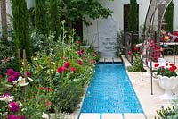 Un large ruisseau d'eau avec des parterres luxuriants à côté d'un coin salon dans le ministère turc de la Culture et du Tourisme: Garden of Paradise.
