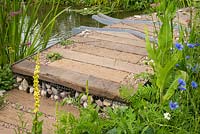 Le WWT Working Wetlands Garden, RHS Hampton Court Flower Show 2016. Designer Jeni Cairns. Passerelle sur le ruisseau