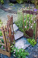 Romantique cour intérieure jardin avec pavage en pierre saule clôtures osier amour coeur ornements chalet d'été plantation pérenne