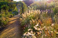 Jardin clos de Cambo, Fife, Scotland, UK, automne, voie, parterre de fleurs, plantation de dérive, herbe ornementale, arch,