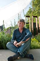 Le concepteur de jardin Andy Sturgeon a l'air cool, partageant l'ombre avec ses plantes dans son jardin télégraphique