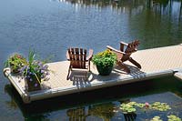 Passerelle sur le lac avec salon de jardin et pots de fleurs