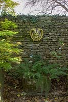 L'Abbey House, Malmesbury, Wiltshire, Royaume-Uni (Pollard). Automne dans un grand jardin, masques 'païens' comme ornement