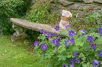 banc en pierre dans le jardin avec sculpture de torse