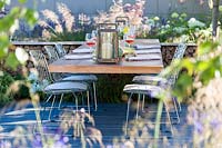 Hampton Court Flower Show 2014, le Vestra Wealth Garden, des. Paul Martin. Table et chaises modernes pour un déjeuner léger en plein air
