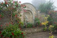 Hodges Barn, Gloucestershire, Royaume-Uni (Hornby) patio avec mur de pierre des Cotswolds et plantes semi-rustiques