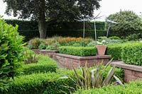 Mitton Manor, Staffordshire. Parterre de jardin formel avec des sculptures en verre 'Suncatcher' de Neil Wilkin