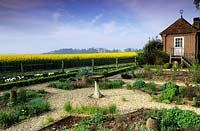 Jardin privé chemins de gravier Sussex avec bain d'oiseaux point focal au printemps gazebo vue du champ de colza