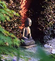 Tilford Cottage Surrey statue de Bouddha en pierre face à l'est dans le jardin japonais