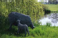 Jardin privé Kent sculptures de moutons en fil de fer par Rupert Till à côté de l'étang et du saule pleureur