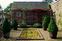 Preen Manor Shropshire petit jardin d'eau formel piscine rectangulaire peu profonde avec des cailloux loggia banc topiaire buis en bois
