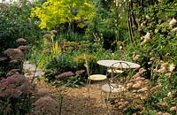 Five Oaks Sussex Table et chaises dans le jardin de gravier Pimpinella major Rosea Robinia Frisia