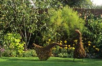 Oies sculpturales de jardin tissées à partir de noisetiers de saule sur pelouse