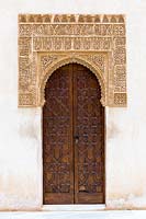 Porte en bois avec artésonados encadrée avec écriture arabe. Patio de Arrayanes,, Palacios Nazaries - Palais Nasrides, l'Alhambra, Grenade.