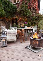 Table de jardin, chaises et panier à feu sur la terrasse du jardin mis en place pour la soirée, Le Mas de Béty, France