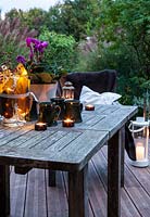 Salon de jardin sur terrasse, aménagé avec bougies et mugs, Le Mas de Béty, France.