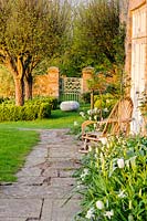 Une vue de la parterre de fleurs, porte du jardin et groupe de Malus hupehensis, Brilley Court Farm, Whitney-on-Wye, Herefordshire, Royaume-Uni.