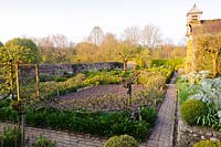 Des allées de briques dans le jardin potager clos passent des parterres bordés de pommes enjambées et d'une boîte clippée. Ferme Brilley Court, Whitney-on-Wye, Herefordshire