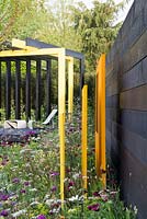 Vue latérale des panneaux sculpturaux en acier jaune dans le jardin 'Urban Oasis', RHS Malvern Spring Festival, 2018.