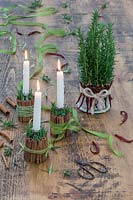 Bougeoirs festifs et pièce maîtresse en bâtons de cannelle, romarin, piments séchés et ruban.
