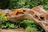 Chêne abattu sculpté d'une scène de chasse sur un côté, par le sculpteur à la tronçonneuse Matthew Crabb. Jardins subtropicaux d'Abbotsbury, Abbotsbury, Dorset, UK.