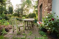 Terrasse avec des plantes et des pots de dahlias, Aston Crews, Herefordshire, Royaume-Uni.