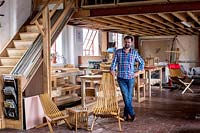 Chris Punch, créateur de mobilier de jardin en atelier, avec gamme de chaises.
