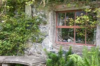 Siège en pierre avec des plantes grimpantes autour de la fenêtre de Bothy - Dyffryn Fernant, UK