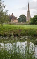 Regardant à travers un étang dans le parc de plaisance d'un jardin médiéval reconstruit Le Manoir Prebendal