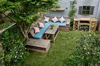 Jardin de la cour avec pelouse artificielle et sièges d'échafaudage récupérés, à l'ouest de Londres