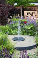 Fontaine circulaire dans un jardin d'exposition - «Un jardin familial», parrainé par l'ACLC, RHS Chatsworth Flower Show, 2018.
